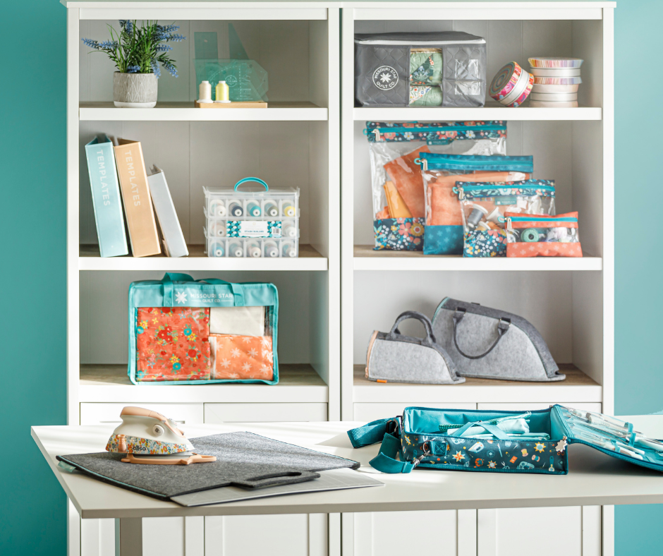Organized sewing room shelves holding precuts, thread and quilting notions