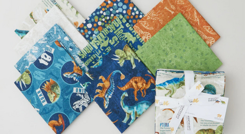 a selection of fat quarter prints from the Dino Roar fabric collection.