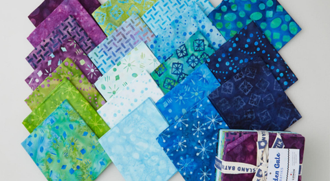 Fat quarter bundle of blue, green, and purple batiks with assorted abstract designs.